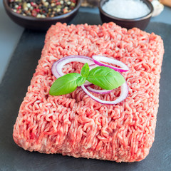 Minced meat from pork and beef. Ground meat with ingredients for cooking on dark slate board,...