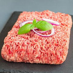 Minced meat from pork and beef. Ground meat with ingredients for cooking on dark slate board,...