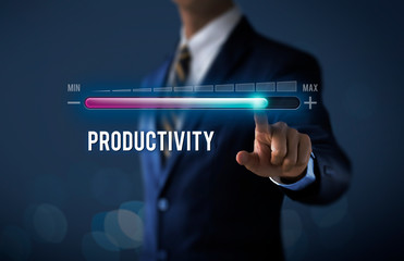 Increase productivity concept. Businessman is pulling up progress bar with the word PRODUCTIVITY on dark tone background. - obrazy, fototapety, plakaty