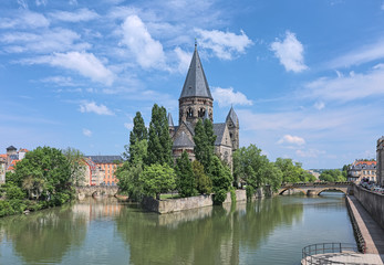 Fototapeta na wymiar Temple Neuf (New Temple), a Protestant city church in Metz, France. View from a bridge across the Moselle river. The church was built in 1901-1904 by design of the German architect Conrad Wahn.