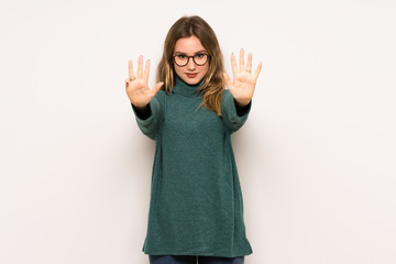 Teenager girl over white wall counting nine with fingers