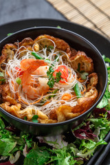 Asian salad with rice noodles with shrimps and vegetables closeup.