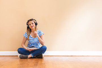 Young woman with headphones and a notebook