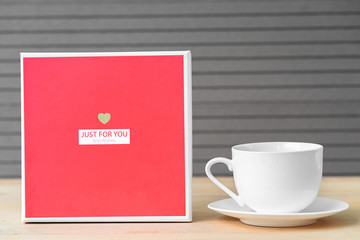 Red roses and coffee cup on wood background