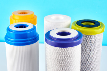 Water filters. Carbon cartridges on a white blue background. Household filtration system.