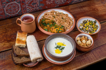 Middle Eastern cuisine dishes in ceramic plates on a wooden table. 