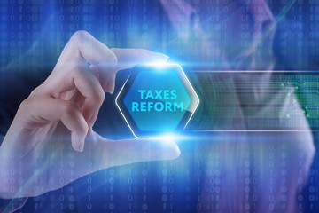 The concept of business, technology, the Internet and the network. A young entrepreneur working on a virtual screen of the future and sees the inscription: taxes reform