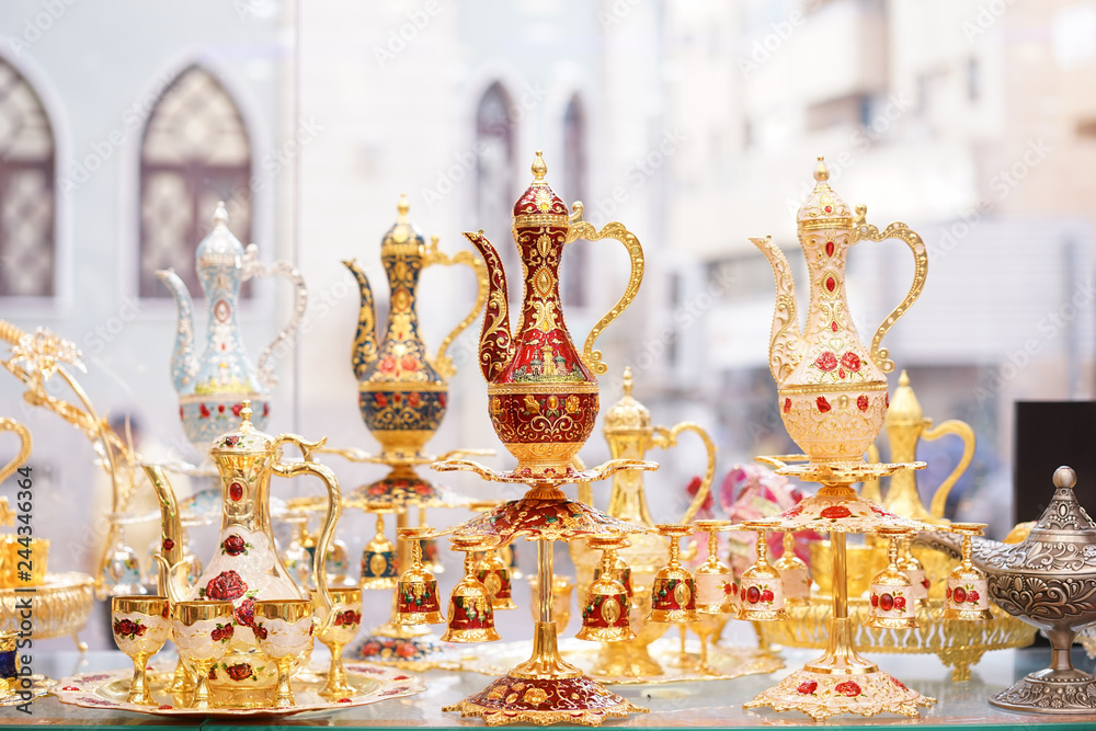 Wall mural Arabic coffee. Arabic jars made from brass, very decorative in arabic style in shiny gold and red. Antique Arabic coffee mugs display at the souvenir shop.