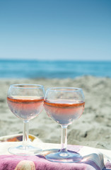 Beach party with sea view, romantic celebration on sunny sandy beach, two glasses with rose wine