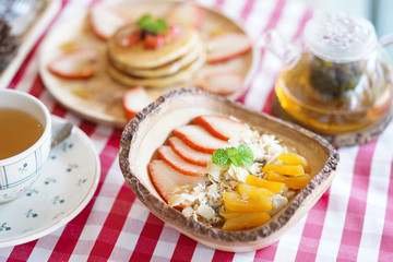 Fototapeta na wymiar Oatmeal. Oatmeal served with fresh fruits such as peaches and strawberries for breakfast.