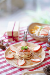 Pancakes. Breakfast menu of strawberry pancakes and oatmeal on the background served on the table with red and white gingham pattern table cloth.