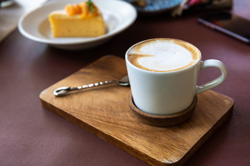 Latte coffee cup on wooden plate