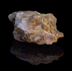 Natural stone hackmanite on a black background with reflection