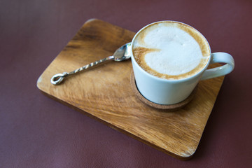 Latte coffee cup on wooden plate