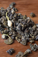 high quality jasmine green tea at wooden desk. macro shot