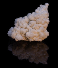 Natural druse of white calcite on a black background with reflection