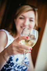 Beautiful young woman is enjoying a glass of wine in the holidays