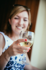 Beautiful young woman is enjoying a glass of wine in the holidays