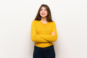 Fototapeta premium Young woman with yellow sweater looking up while smiling