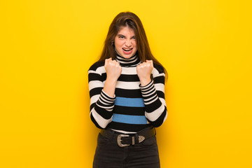 Young woman over yellow wall frustrated by a bad situation