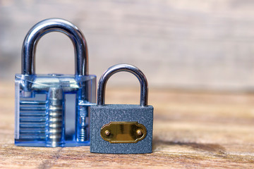 Plastic and iron padlocks on a wooden table