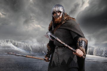 Medieval Scandinavian warrior Viking in full outfit on shore of winter sea
