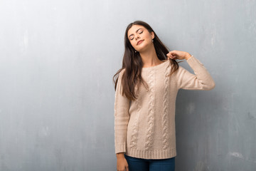 Teenager girl with sweater on a vintage wall with tired and sick expression