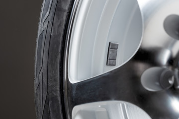 A fragment of the wheel of a car with a balancing weight