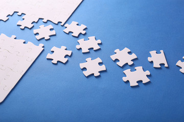 On a blue background, white puzzles and the missing piece