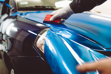 Car wrapping specialist putting vinyl foil or film on car. Selective focus. © hedgehog94