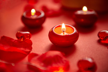 Romantic dinner decoration. Red candles, flower petals, on the table. Selective focus shot. Valentine or Love concept.