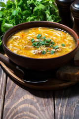 chicken soup with egg noodles in a bowl, vertical