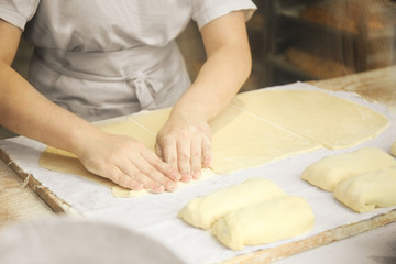 Obraz na płótnie Canvas Hands of the cook gently knead dough. Little family bakery.