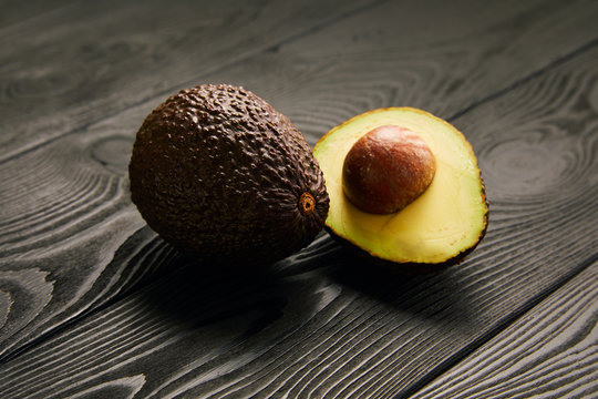 Image of avocado on black wooden background