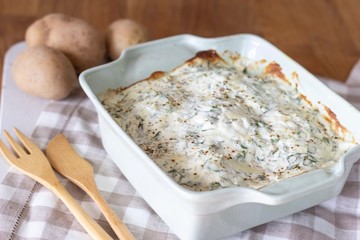 baked potato cheese sauce and herbs in the form for baking, moussaka