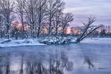Foto auf Leinwand winter landscape with trees in snow on riverbank © photollurg