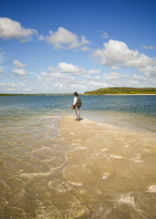 Man at the tip of Coroa do Aviao islet, Itamaraca island on the right - Pernambuco, Brazil