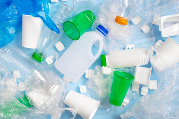 Various plastic garbage on the light blue background