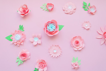 Different pink paper flowers on pink background