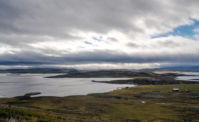 Fototapeta na wymiar Lake in the prairies of the interior of southern Norway on a cloudy day.