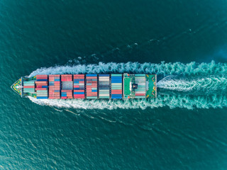 Aerial top view container ship full speed for logistics , import export, shipping or transportation.