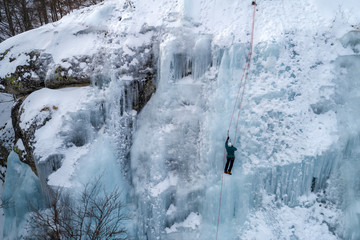 Ice climbing the North Greece, man climbing frozen waterfall.