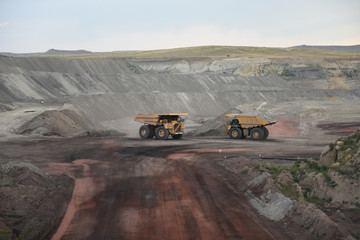 Giant coal mining trucks pass each other inside an open pit coal mine in the Powder River Basin, Wyoming