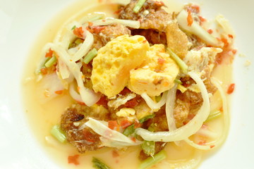 spicy fried egg cutting with onion Thai salad on plate