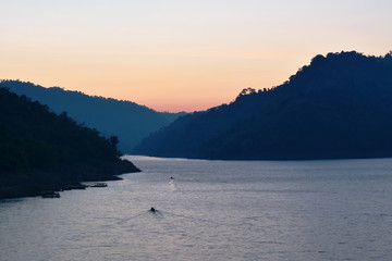 Fototapeta na wymiar sunrise behind mountain on river in Thailand