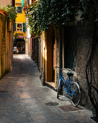 An old bike rests against a wall in a side street in Garda, Italy