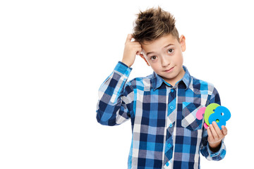Cute boy with dyscalculia holding large colorful numbers and scratching his head. Learning...