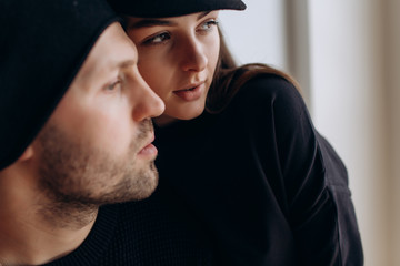 Two hipster models: a man and a woman in a blank black t-shirt, jeans and posing. in a black hat, cap, love, kisses