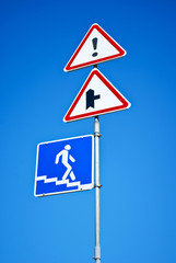 Road signs and pointers against blue sky