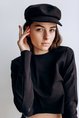 Beautiful girl in a black cap, black golf, blue jeans! Natural light, smart casua, street casual